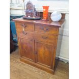 An Edwardian walnut bachelors cabinet, the raised back over two short drawers, one fitted for