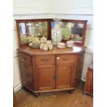 A late Victorian mahogany corner side cabinet, the raised back with bevelled mirrors over dummy