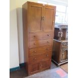 A mahogany cabinet, with two panelled doors over four long drawers and two further panelled doors,