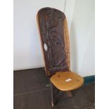 An African hardwood backstool, the back carved with a duck catching fish, 72cm high