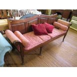 A late George III mahogany hall settee, the shaped panelled back over upholstered scroll arms on