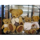 Four various teddy bears, three with white wool jumpers, the other with tweed waistcoat
