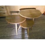A nest of three Ercol pebble design ash and elm tables, largest 65cm wide, labelled