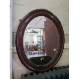 An Edwardian oval wall mirror, with tortoise shell effect moulded frame, 62cm x 52cm