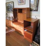 A small teak side cabinet with glazed door and fall front above, two drawers beside a cupboard
