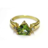 A peridot and diamond ring set in 9 carat yellow gold