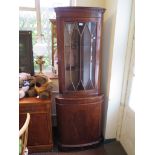 A reproduction mahogany corner cabinet, with glazed and oval veneered doors, 65cm x 101cm