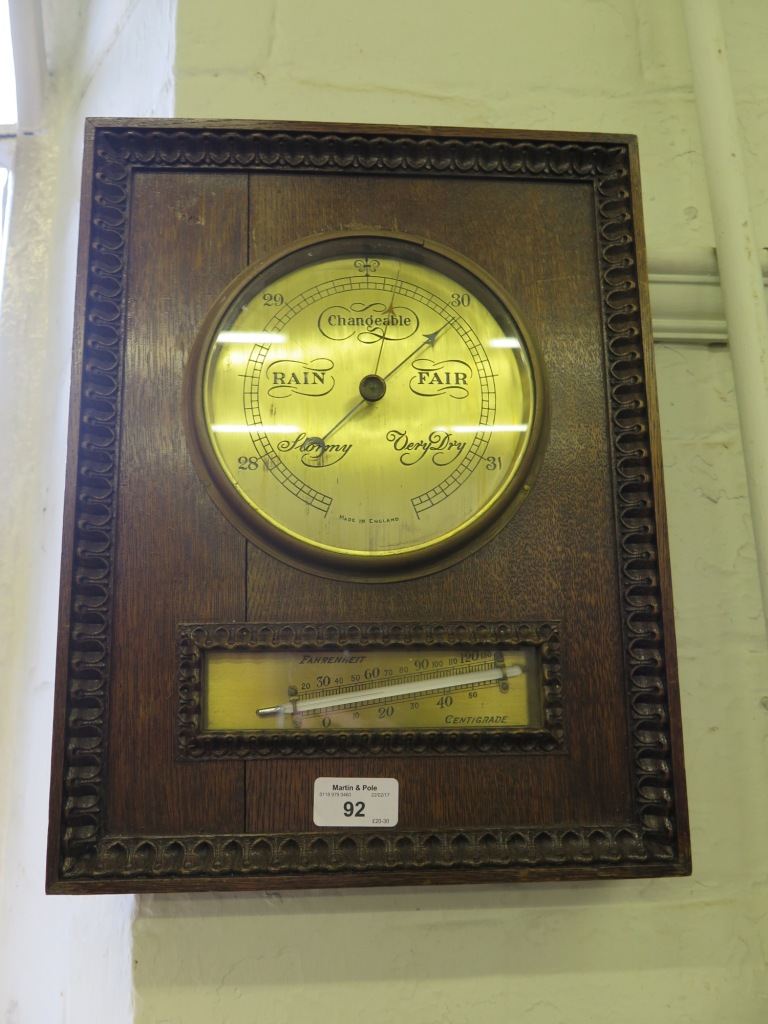 A 1930's rectangular oak barometer, with tongue and dart border, enclosing a brass dial and