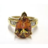 A topaz and diamond ring set in 9 carat yellow gold