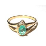 An emerald and diamond ring set in 9 carat yellow gold