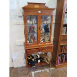 A yewwood veneer crossbanded display cabinet, with patera raised back, glazed doors and two