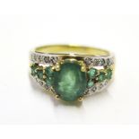 An emerald and diamond ring set in 9 carat yellow gold