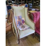 An Edwardian stained beech and upholstered wing armchair with square cabriole legs and pot