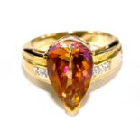 A topaz and diamond ring set in 9 carat yellow gold