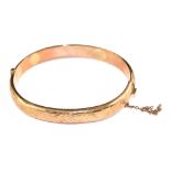 A ladies 9 carat gold bangle with chased decoration