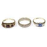 A small collection of three rings to include a garnet and paste ring in 9 carat gold and an eternity