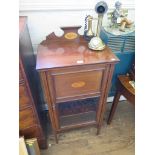 An Edwardian mahogany and feather banded cabinet, the raised back and glazed door with shell motif