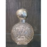 A round cut glass scent bottle with stopper and silver top