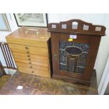 An Edwardian stained oak smokers cabinet with lead glazed door 51cm high and a slide case with