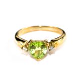 A peridot and diamond ring set in 9 carat yellow gold