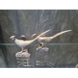 A pair of white metal menu holders depicting pheasants