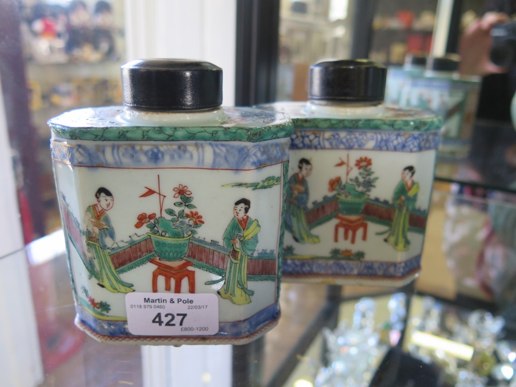 A pair of Chinese Export octagonal tea caddies, with later turned ebony covers, the panels depicting