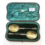 A pair of Victorian decorative spoons having a cast traveller finial, gilt bowl, London 1894 in