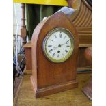 An Edwardian oak and chevron banded mantel clock, the lancet arched case with inlaid patera