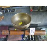A brass singing bowl and turned striking stick, 11cm diameter