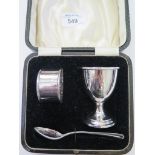 A child's silver egg cup, napkin ring and spoon, cased