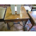 An Edwardian walnut envelope table, with frieze drawer on turned legs joined by an undershelf,