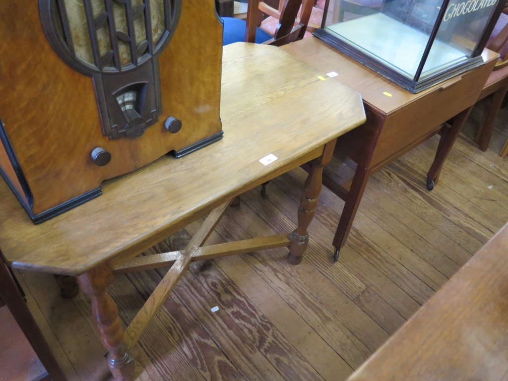 An oak octagonal occasional table on turned legs and cross stretchers, 91cm wide and a teak sewing