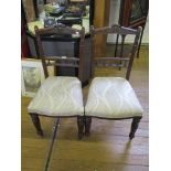 A pair of Edwardian stained beech dining chairs, the carved top rails over spindle turned mid