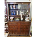 An oak dresser and rack, the rack with glazed slides over two drawers and two cupboard doors on