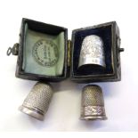 A boxed silver thimble and two others