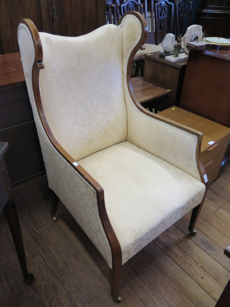 An Edwardian boxwood strung mahogany wing armchair, the scroll wings above straight arms and