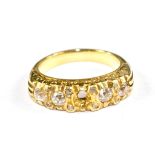 A four stone cushion cut diamond ring set in gold colour metal