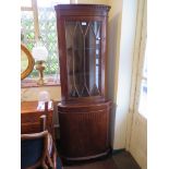 A reproduction mahogany corner cabinet, with glazed and oval veneered doors, 65cm x 101cm