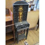 A carved oak stand, with Minton tiles depicting a foliate urn motif, with mask carved drawer and