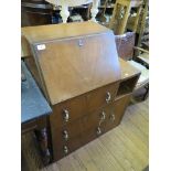 A 1930's walnut bureau, the sloping fall over three drawers beside a compartment and cupboard