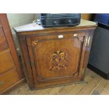 A George III oak offset corner cupboard, the panelled door with inlaid spandrals and central oval