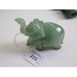 A green jadeite figure of a passing elephant, 7cm high