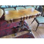 A Victorian rosewood fold over card table, the shaped top and frieze on a tapering cylindrical