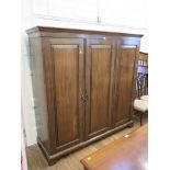 A mahogany wardrobe with three panelled doors on bracket feet 186cm wide, 59cm deep, 182cm high