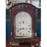 A Regency rosewood and brass inlaid bracket clock, the arched case with grape and vine ring handles,