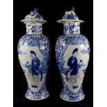 A pair of Chinese blue and white baluster vases and covers, the domed covers with dogs, over