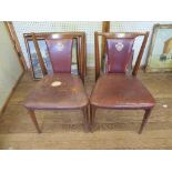 A pair of 1950's teak dining chairs, with leather back and seat impressed with the coat of arms