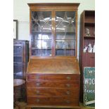 A George III mahogany bureau bookcase, the cavetto moulded cornice over a pair of glazed doors,