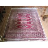 A Turkoman wool mix rug with four red lozenges in a multiple border, 175cm x 120cm