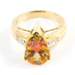 A topaz and diamond ring set in 9 carat yellow gold